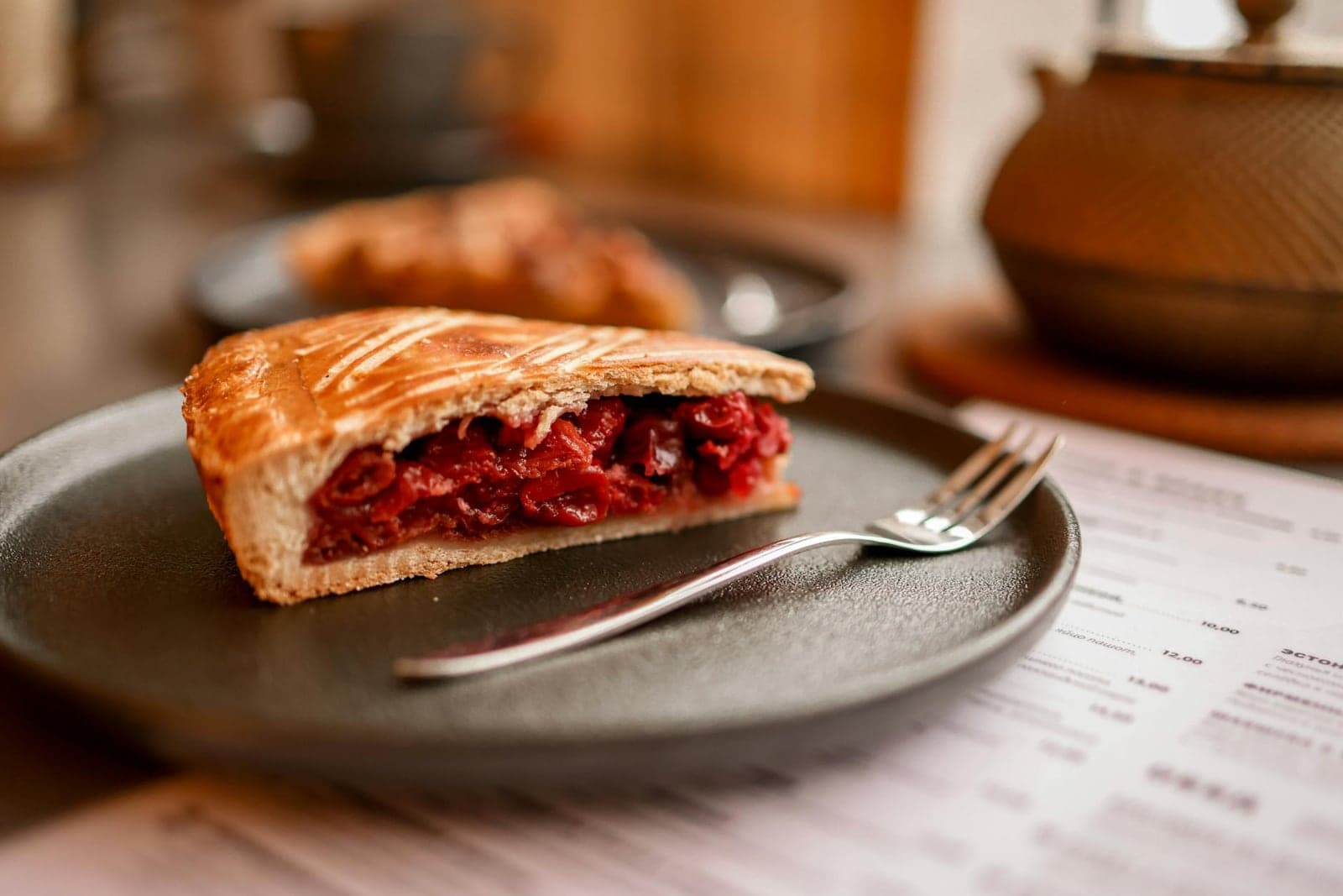 Cherry pie slice with ruby fruit filling and flaky crust served on a plate