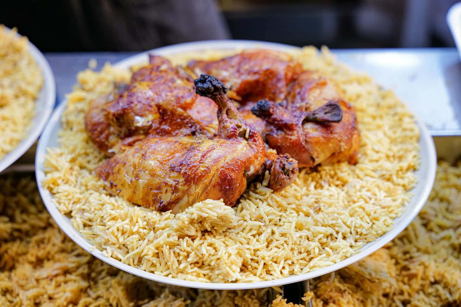 Chicken biryani with spiced rice and browned chicken served on a large platter