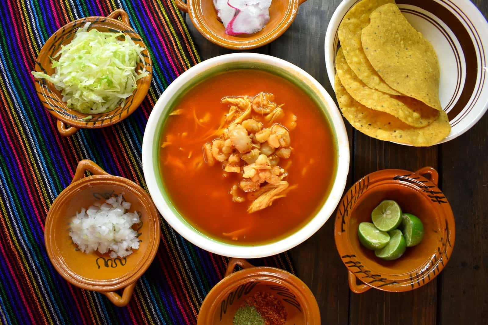Chicken tortilla soup with tomato broth, tortilla chips, lime, and fresh toppings