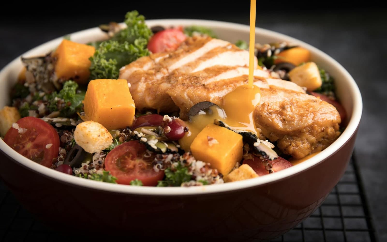 Chipotle chicken quinoa bowl with grilled chicken, grains, vegetables, and creamy dressing
