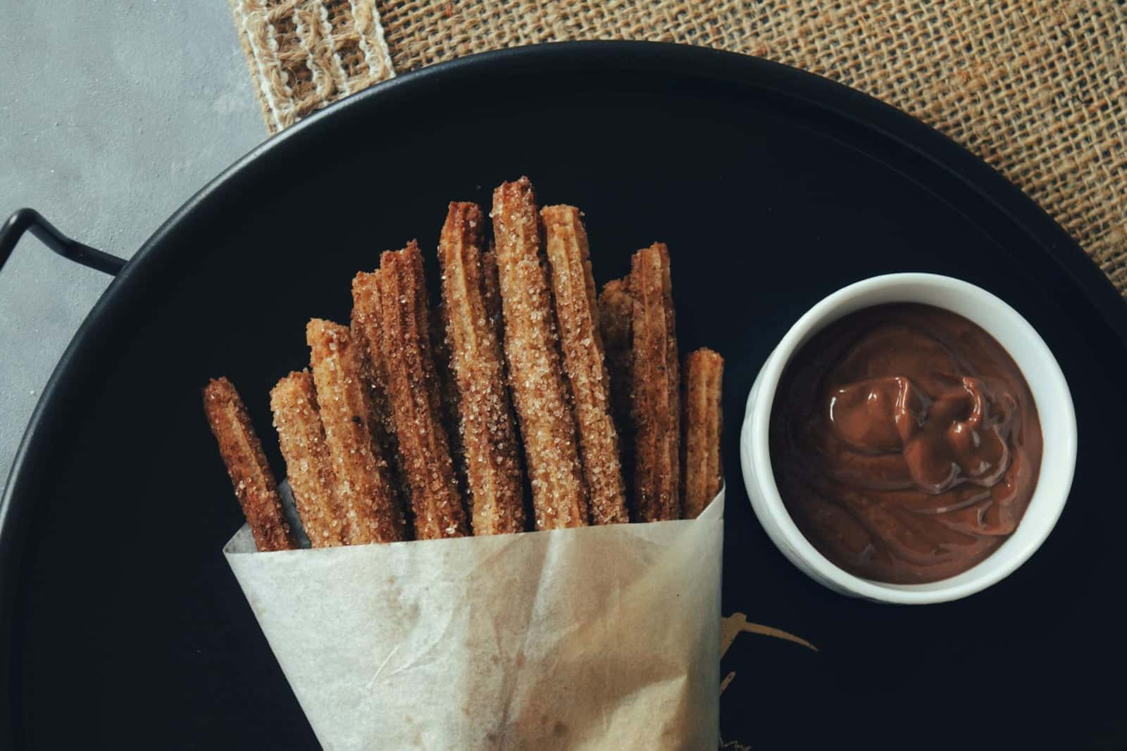 Spanish churros served with a cup of thick chocolate dipping sauce