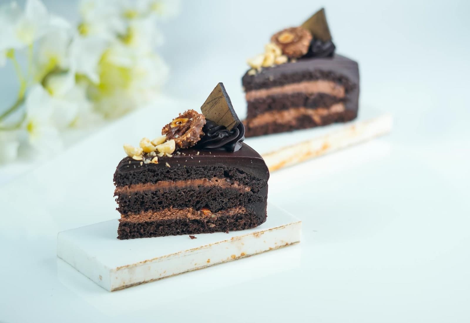Classic chocolate cake slices with dark chocolate layers and decorative toppings