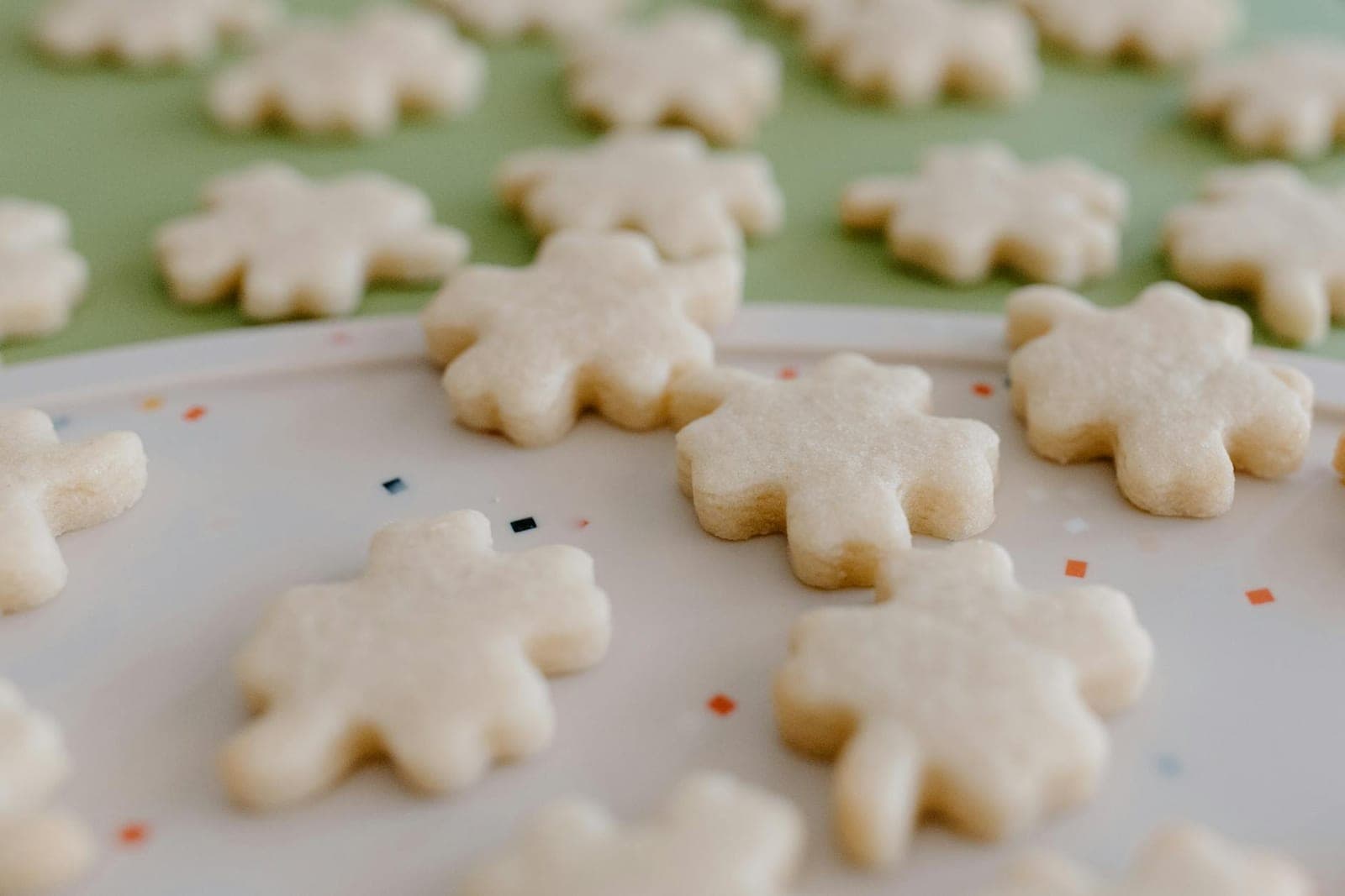 Classic sugar cookies cut into snowflake shapes and arranged on a decorative plate
