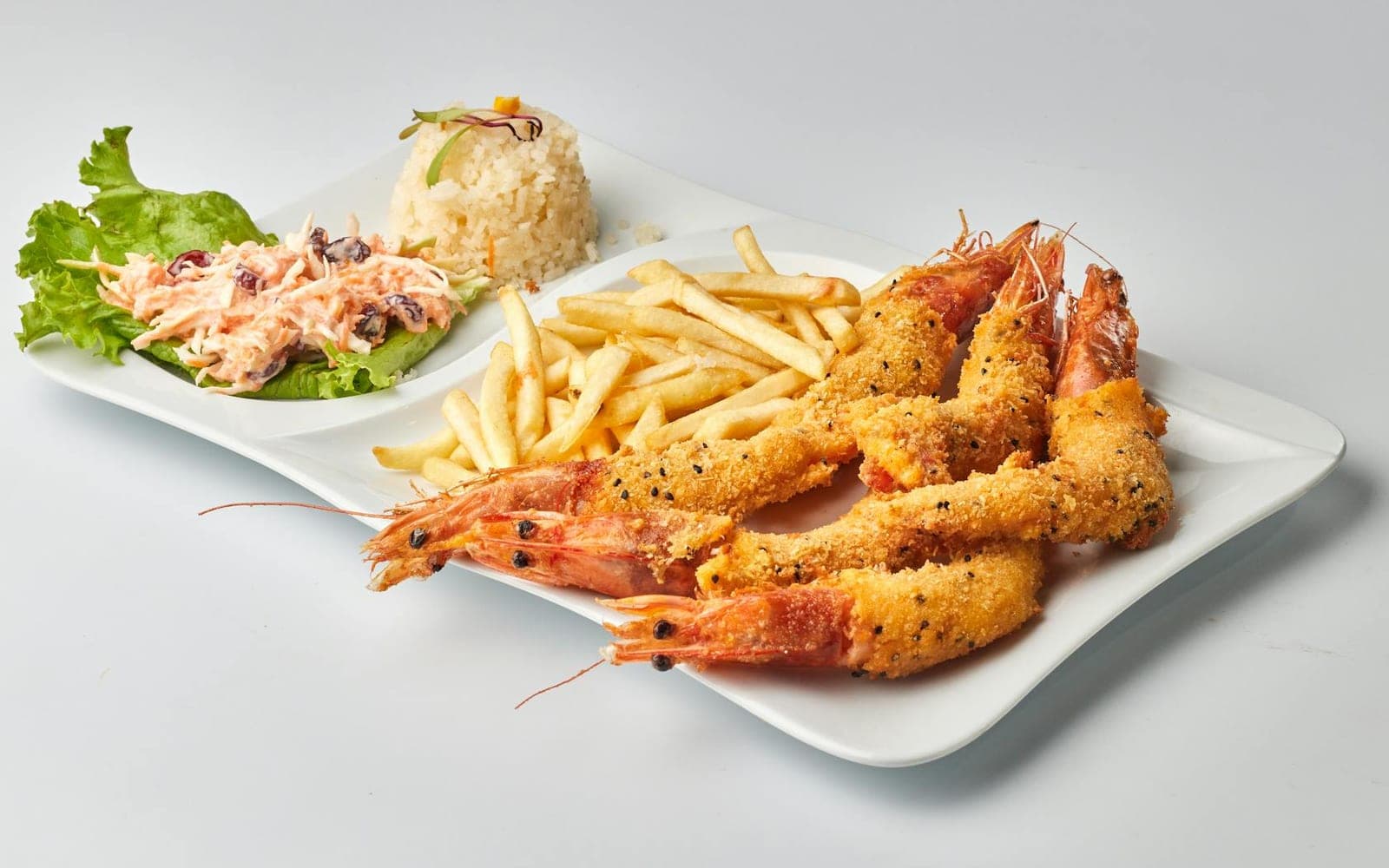Crispy coconut shrimp-style breaded shrimp with fries, rice, and salad