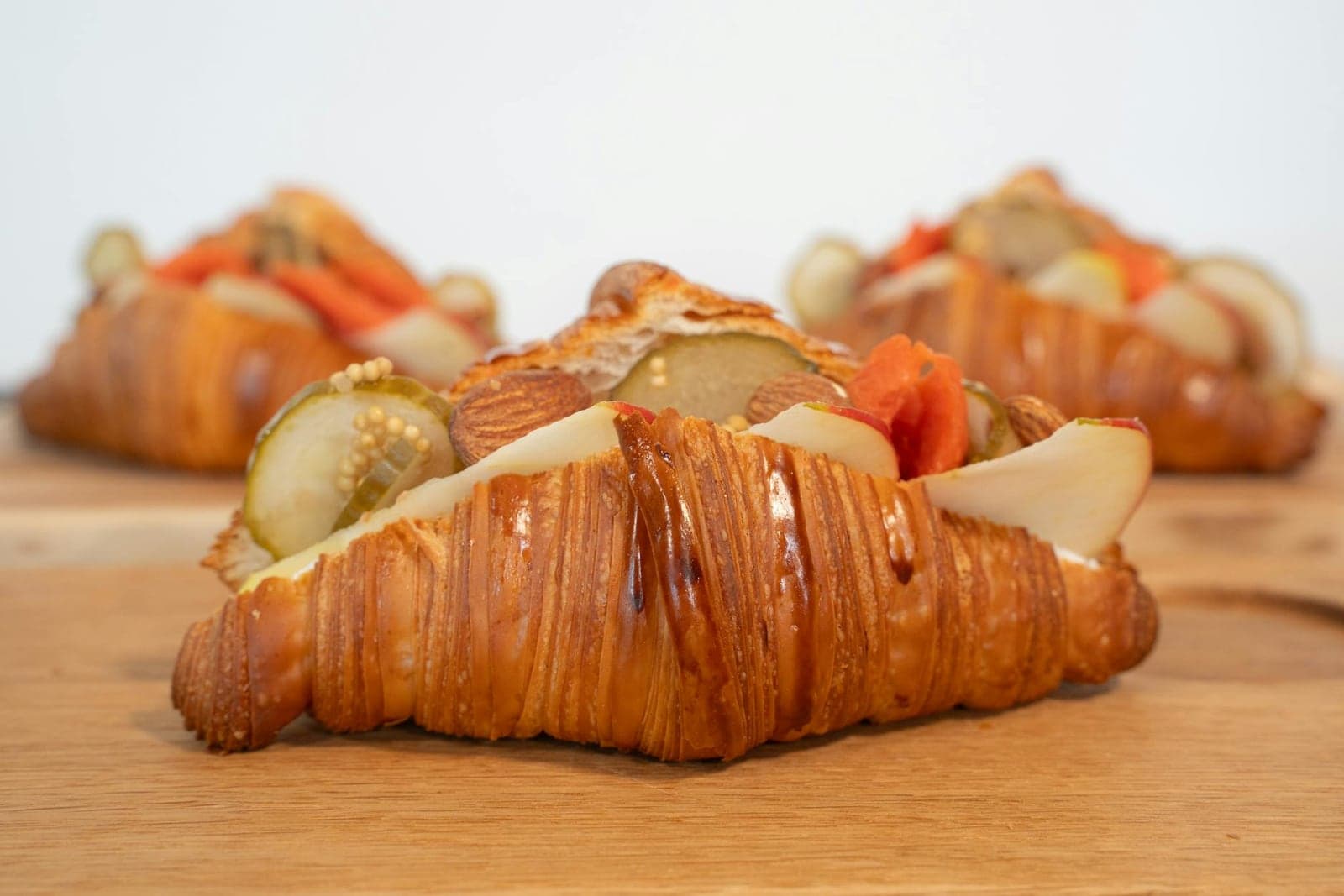 Croissant breakfast sandwich with vegetables and filling on a wooden board