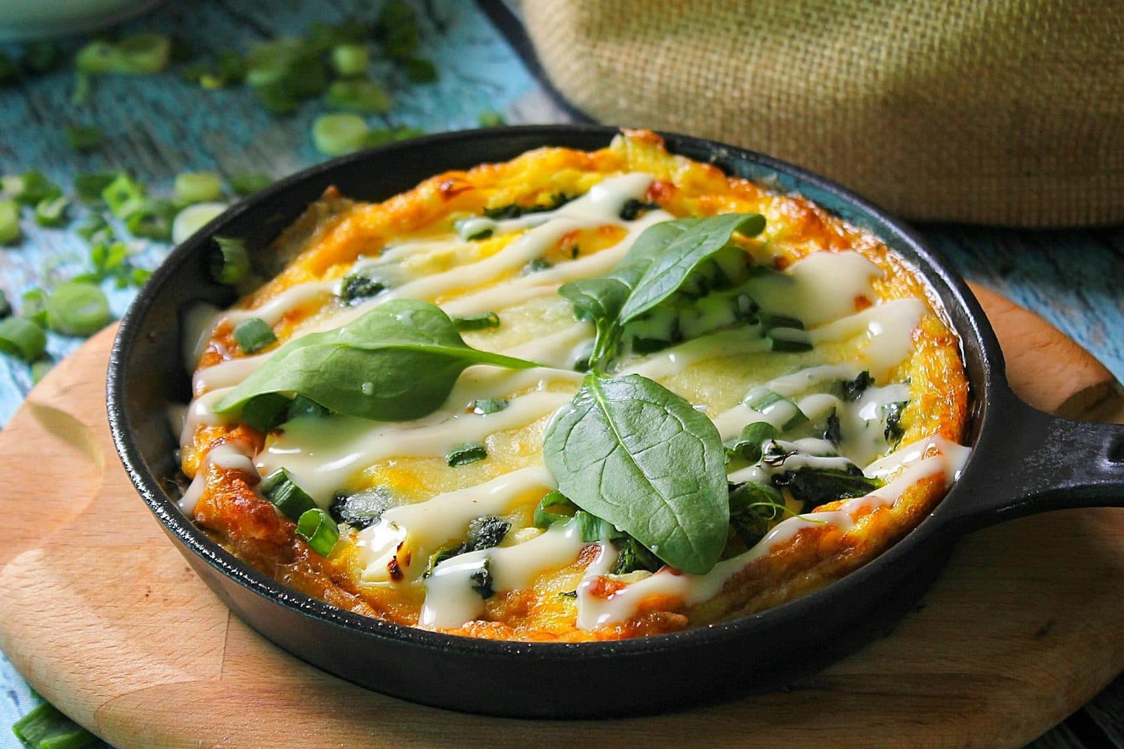 French baked eggs Florentine in a skillet with spinach, cheese, and set eggs
