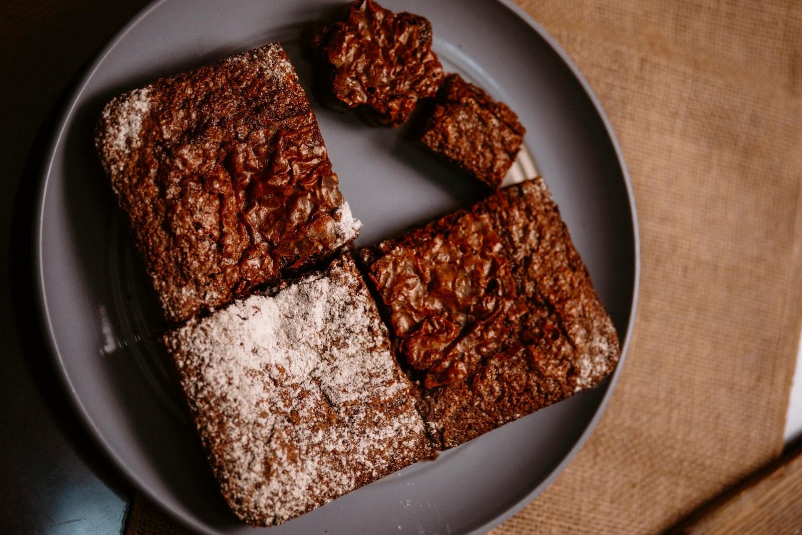 Fudgy chocolate brownies cut into squares with a shiny crackly top