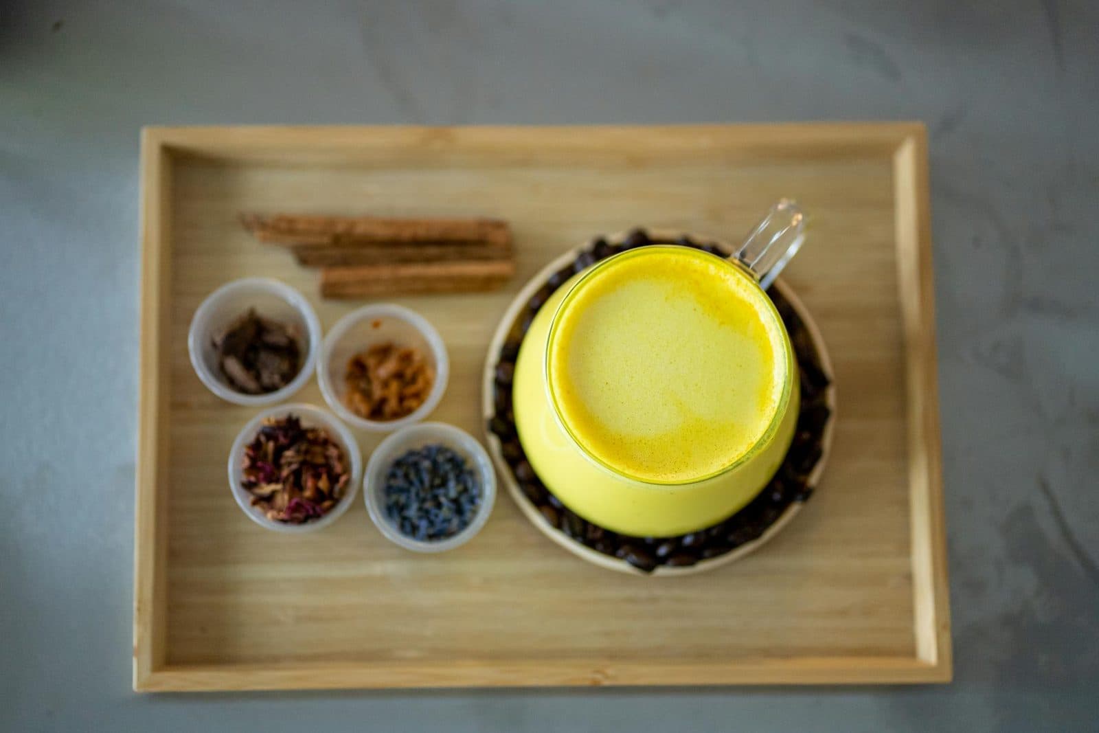Golden milk latte with turmeric spices arranged around a bright yellow drink