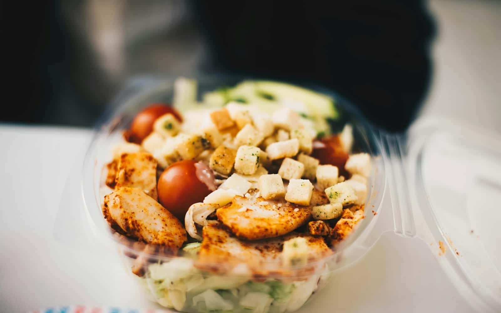 Greek chicken meal prep bowl with chicken, greens, tomatoes, and feta-style toppings