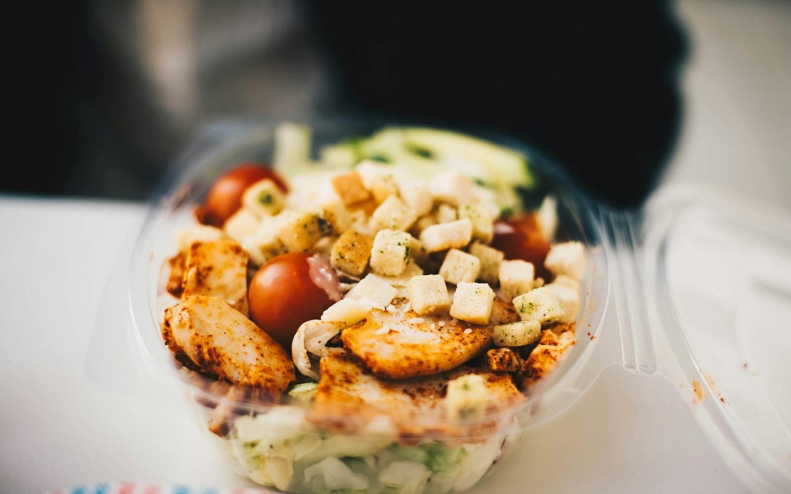 Greek chicken meal prep bowl with chicken, greens, tomatoes, and feta-style toppings