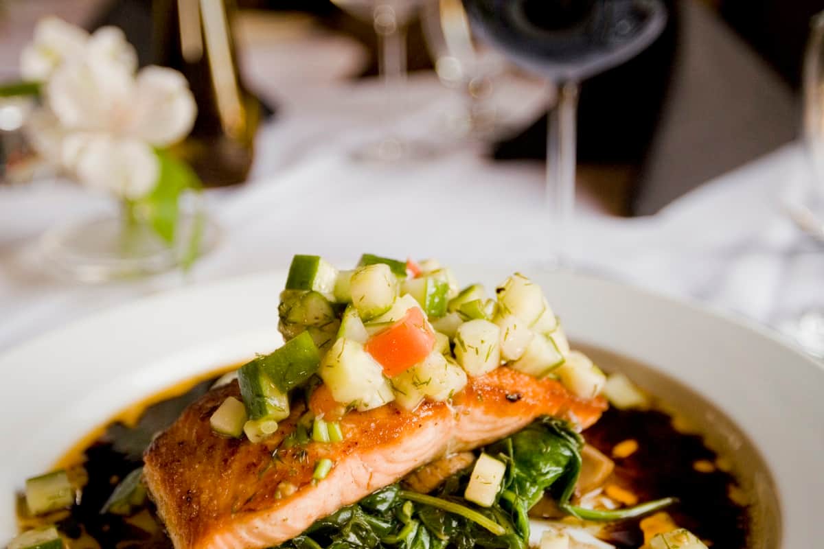 Glazed honey garlic salmon fillet on a plate with sesame seeds and green onions