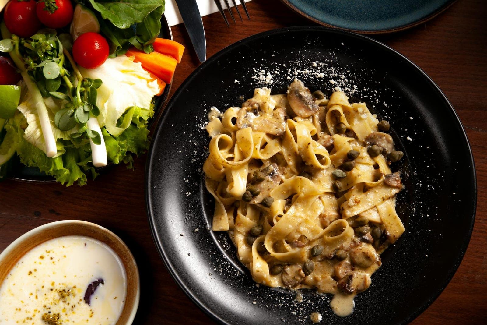 Japanese miso butter mushroom pasta with mushrooms and creamy sauce on a black plate