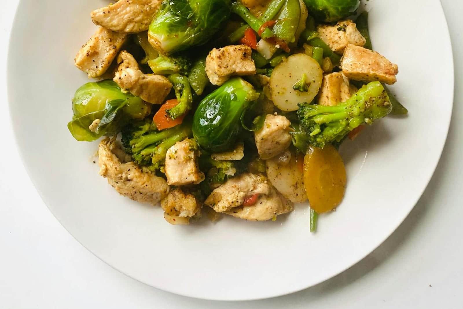 Garlic parmesan chicken and broccoli with vegetables on a white plate
