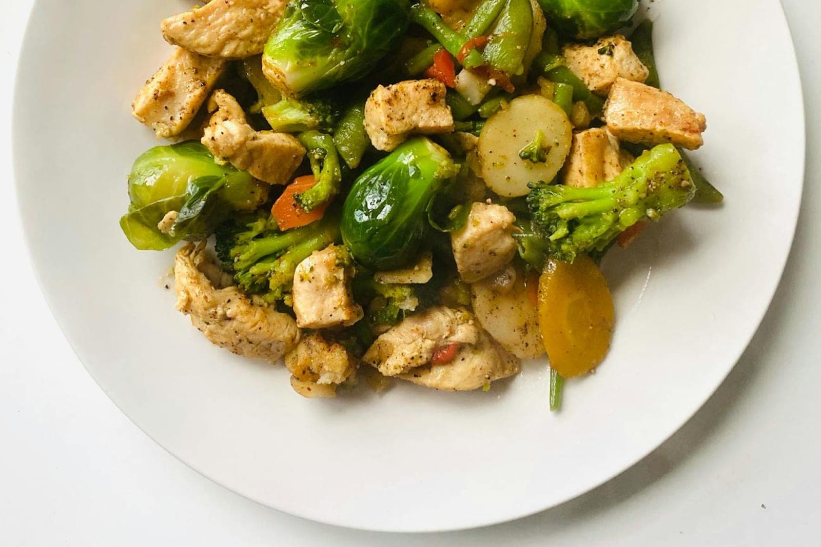 Garlic parmesan chicken and broccoli with vegetables on a white plate