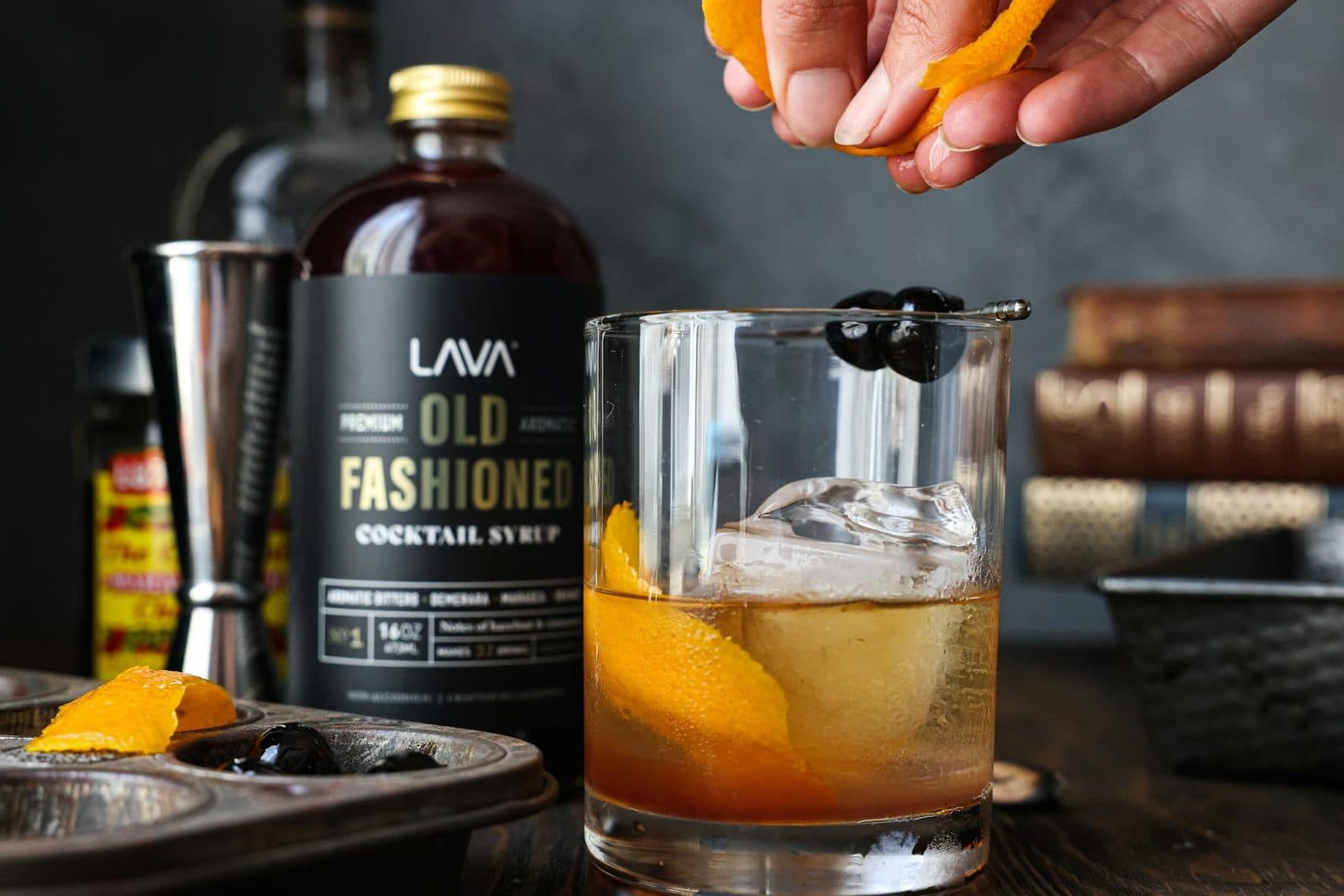 Old fashioned cocktail with orange peel and syrup on a polished bar setup