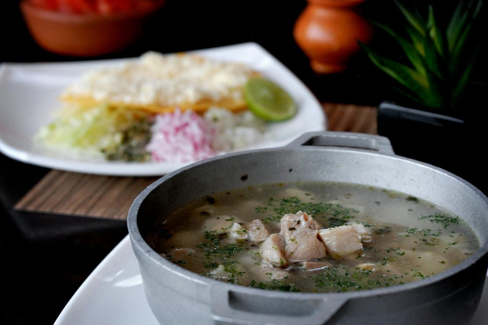 Pozole verde soup with hominy, chicken, green broth, radishes, lime, and herbs