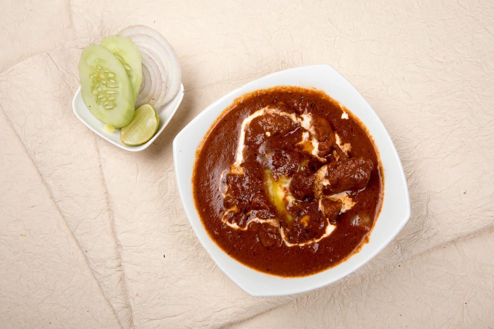 Rajma kidney bean curry with cucumber, onions, lime, and a rich red sauce