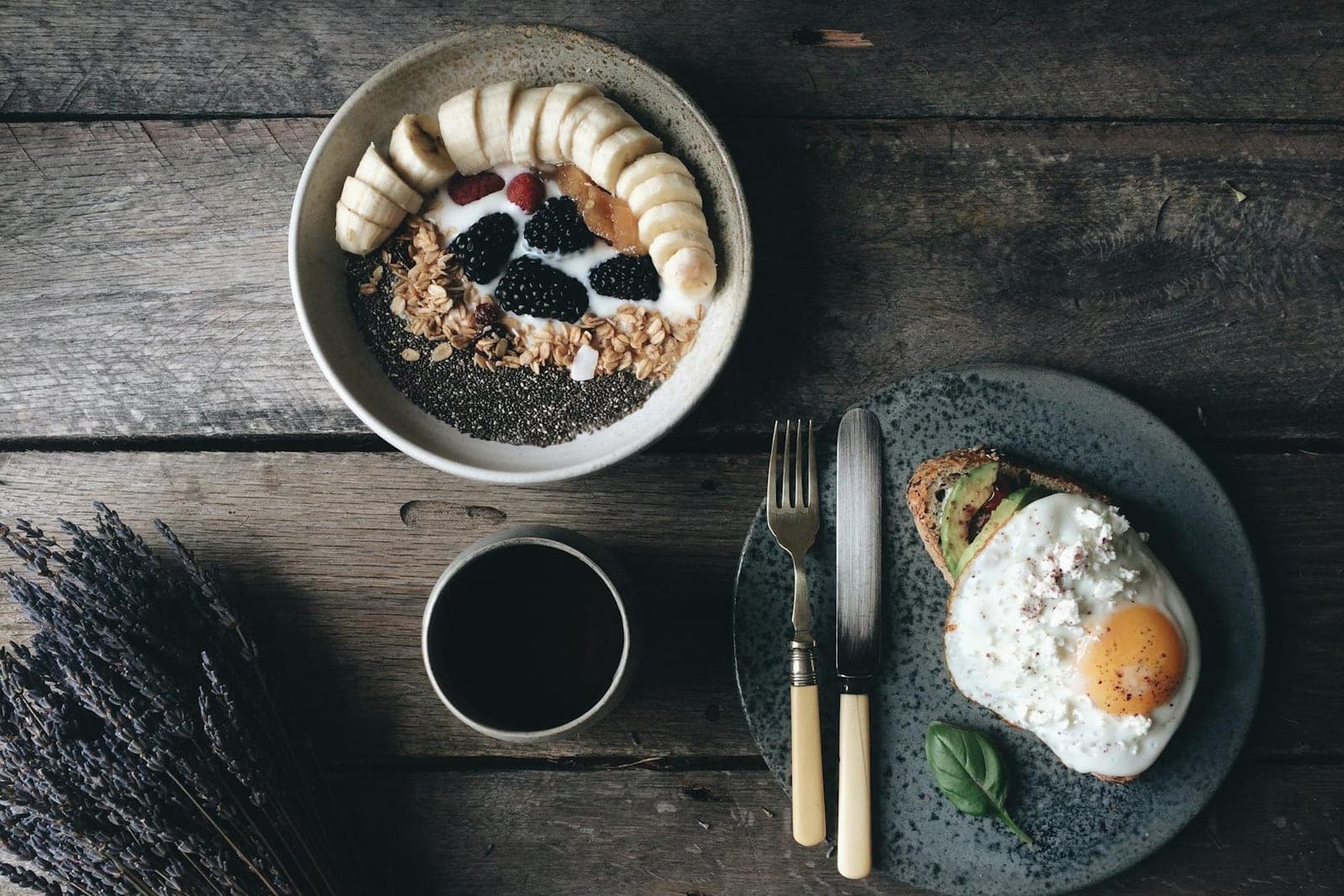 Savory oatmeal breakfast bowl with egg, avocado toast, seeds, and coffee