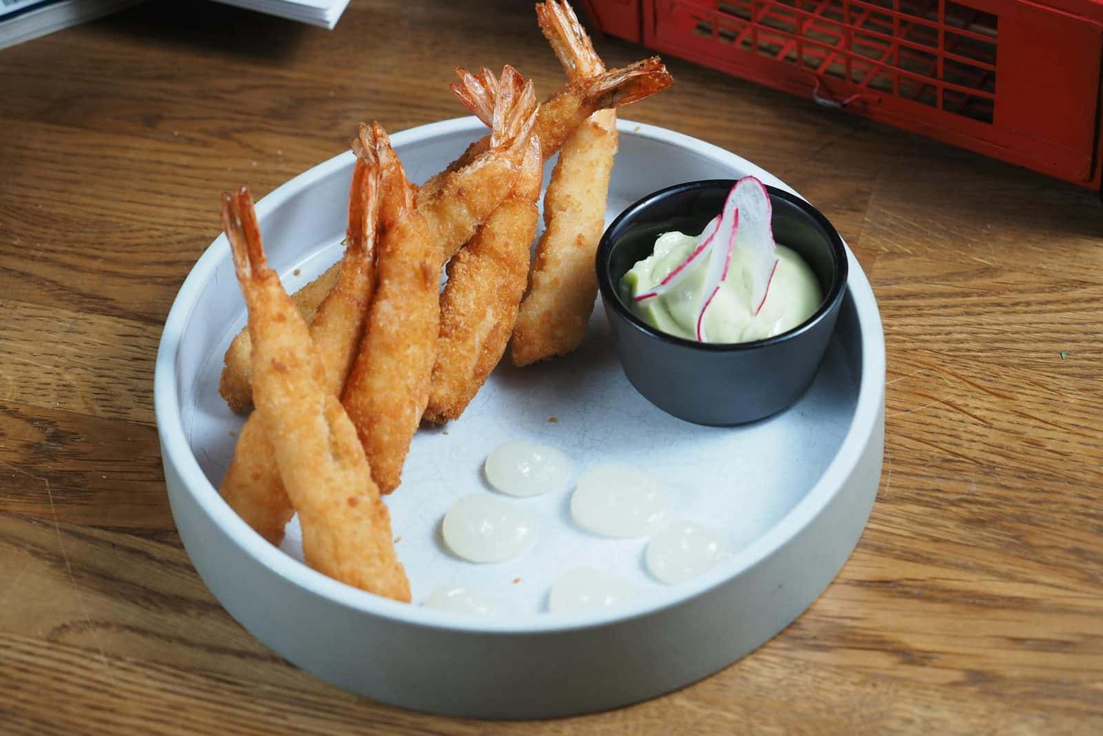 Shrimp tempura with crisp golden batter and creamy dipping sauce on a wooden table