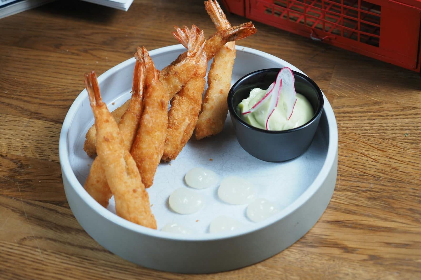 Shrimp tempura with crisp golden batter and creamy dipping sauce on a wooden table