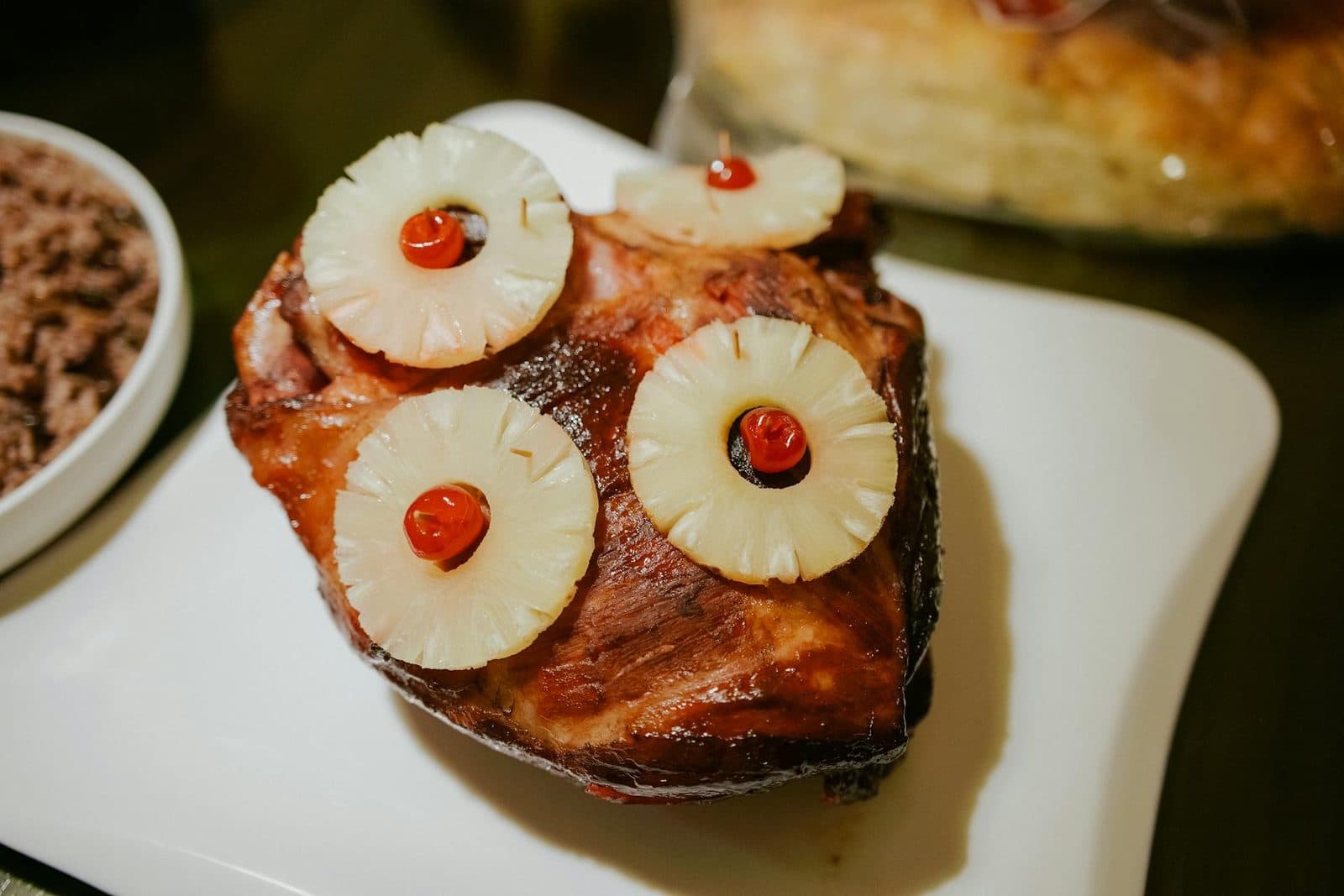 Brown sugar glazed ham with pineapple slices and cherries ready for slicing