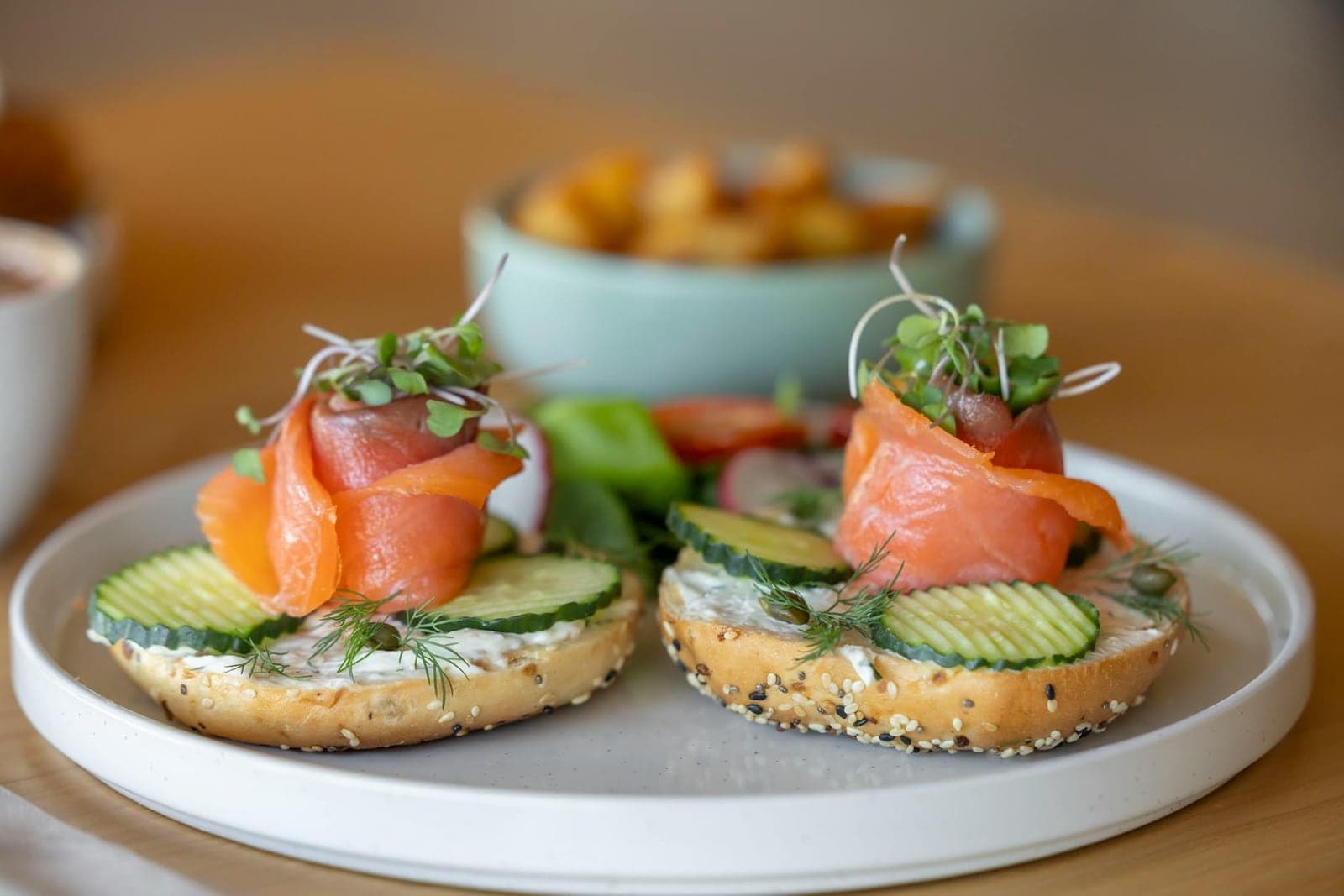 Smoked salmon bagels with cream cheese, cucumber, herbs, and brunch sides