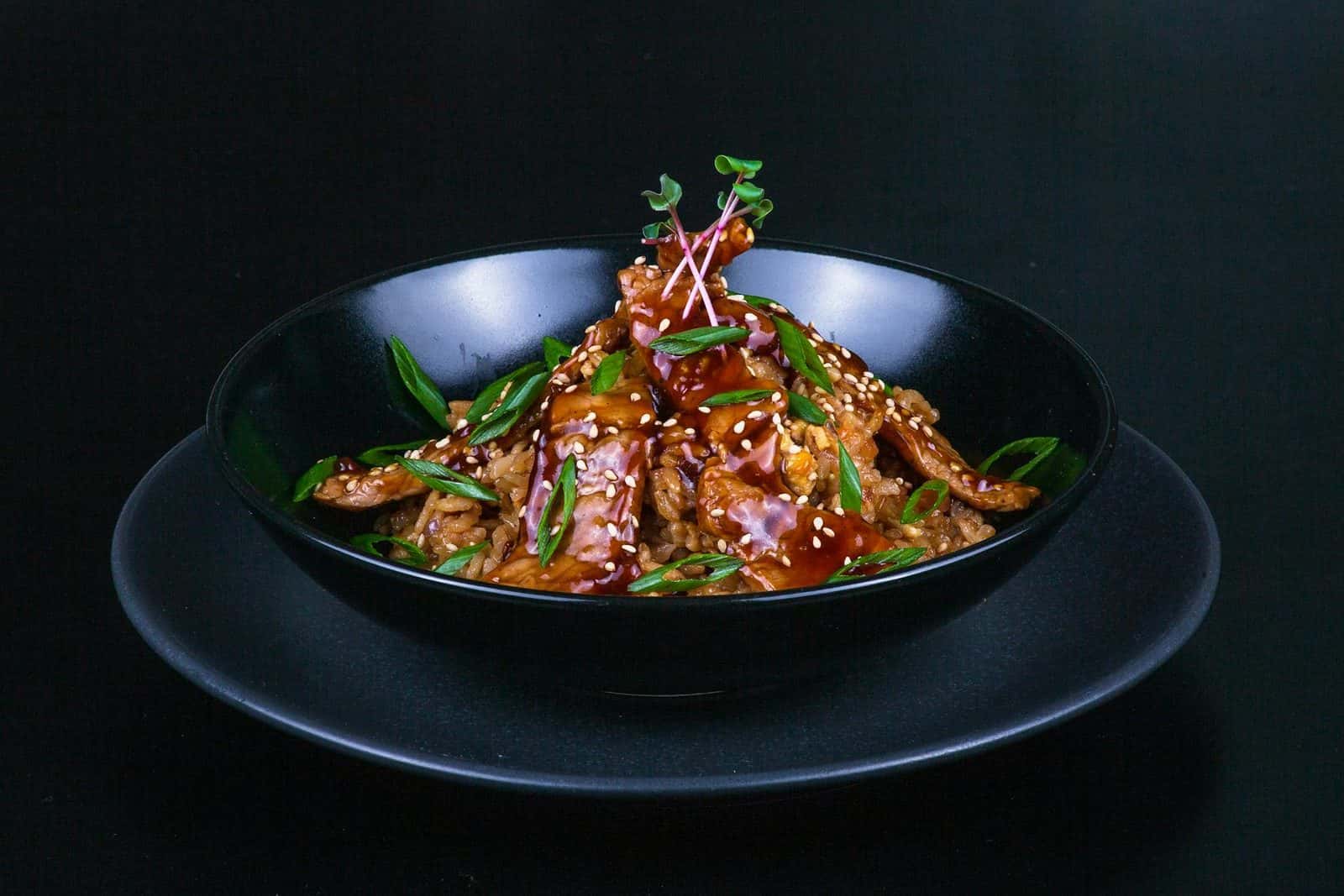 Family teriyaki chicken served with rice, sesame seeds, and sliced scallions