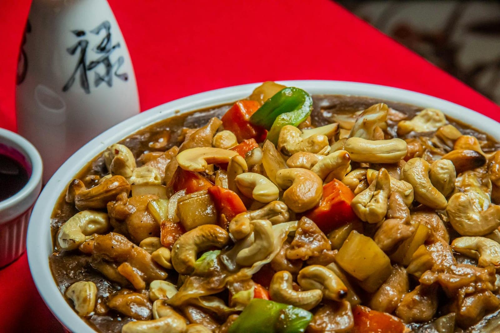 Thai cashew chicken stir-fry with vegetables, cashews, and glossy sauce in a bowl