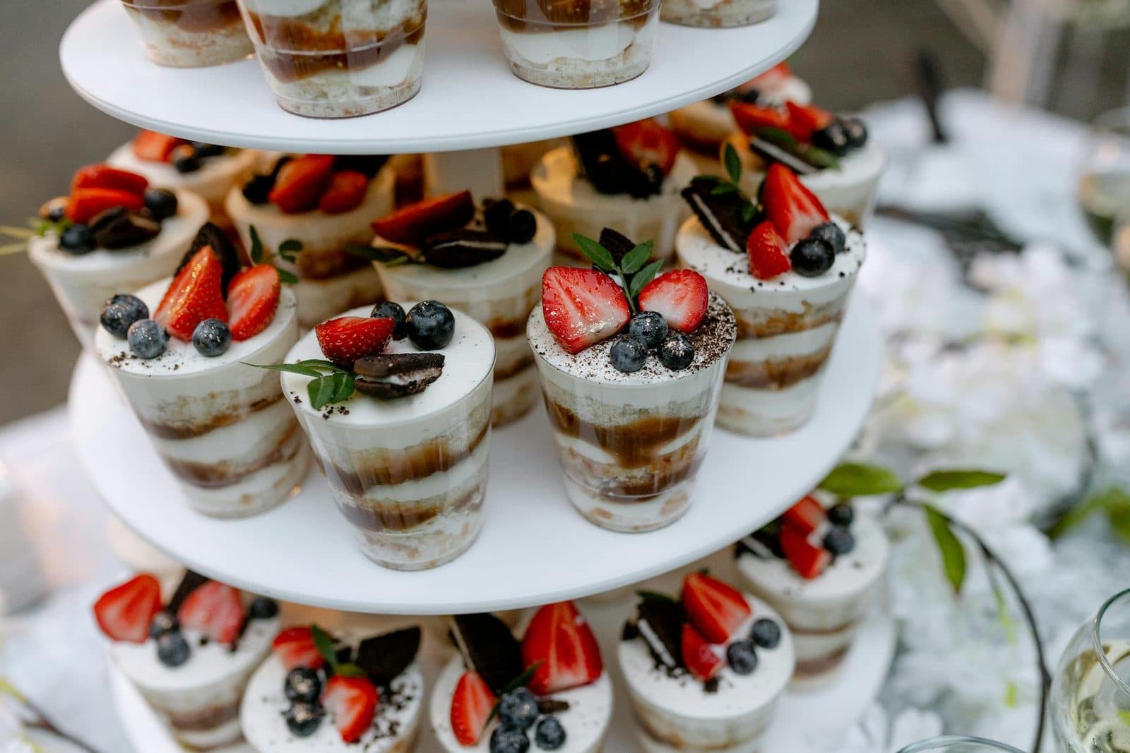 Individual tiramisu cups layered with cream and topped with berries